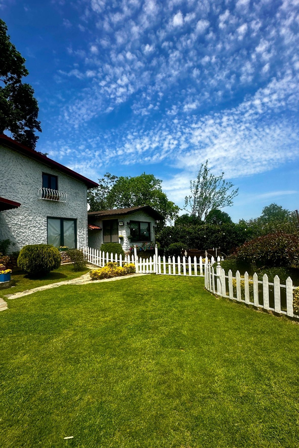 Maison résidentielle avec clôture blanche délimitant un terrain gazonné dans un environnement calme à Kirkland